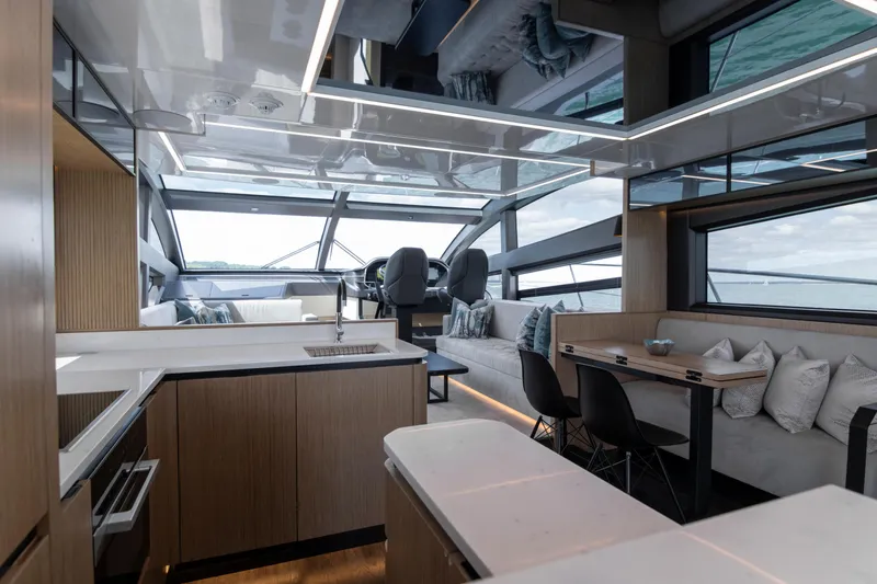 Madness V Yacht Photos Pics Luxurious interior of 2022 Pearl 62 yacht with modern kitchen and seating area.