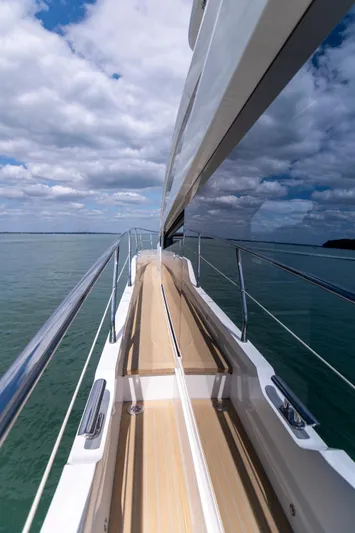 Madness V Yacht Photos Pics Side view of 2022 Pearl 62 yacht on calm sea under cloudy sky.