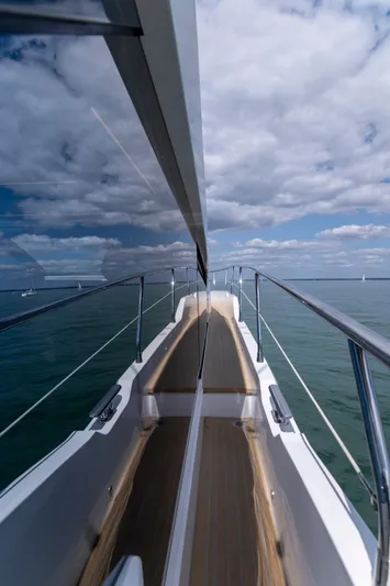 Madness V Yacht Photos Pics Luxury Pearl 62 yacht deck with ocean view, 2022 model, under a partly cloudy sky.