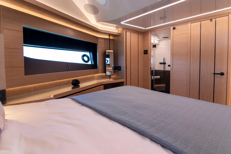 Madness V Yacht Photos Pics Luxurious bedroom interior of 2022 Pearl 62 yacht with modern design and ambient lighting.