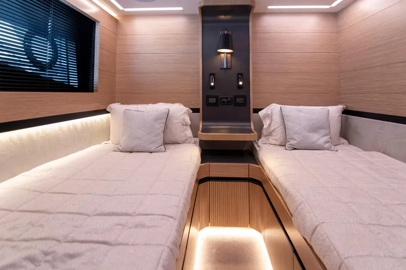 Madness V Yacht Photos Pics Luxurious 2022 Pearl 62 yacht cabin with twin beds and modern lighting.