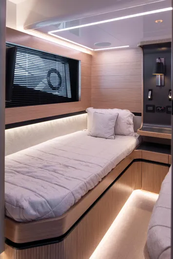 Madness V Yacht Photos Pics Luxurious cabin interior of 2022 Pearl 62 yacht with modern lighting and cozy bedding.