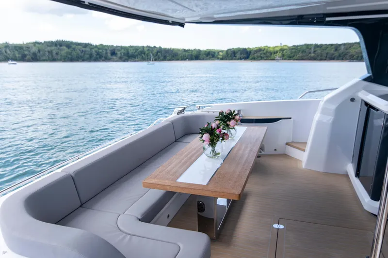 Madness V Yacht Photos Pics Luxurious Pearl 62 yacht deck with elegant seating and floral centerpiece, 2022 model.
