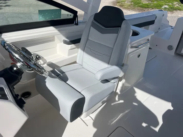  Yacht Photos Pics 2025 Robalo R257 Dual Console boat interior with sleek captain's chair and steering wheel.