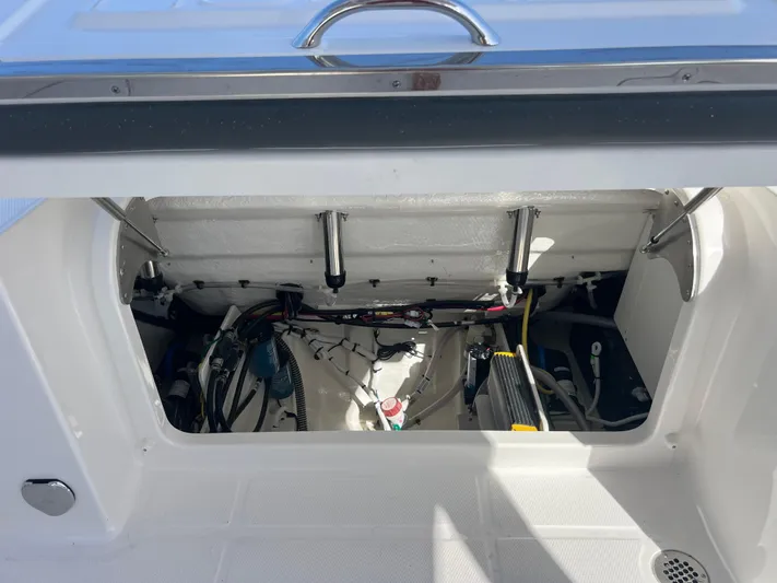  Yacht Photos Pics 2025 Robalo R257 Dual Console boat storage compartment with visible wiring and components.