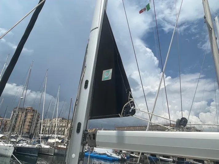 Metis Yacht Photos Pics Beneteau Sense 43 sailboat mast in marina, cloudy sky, Italian flag visible.