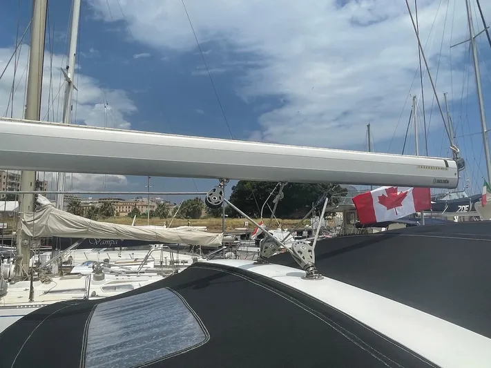 Metis Yacht Photos Pics Beneteau Sense 43 sailboat with Canadian flag, docked under a partly cloudy sky.