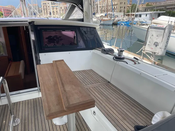 Metis Yacht Photos Pics Cockpit of 2012 Beneteau Sense 43 yacht with wooden seating and marina view.