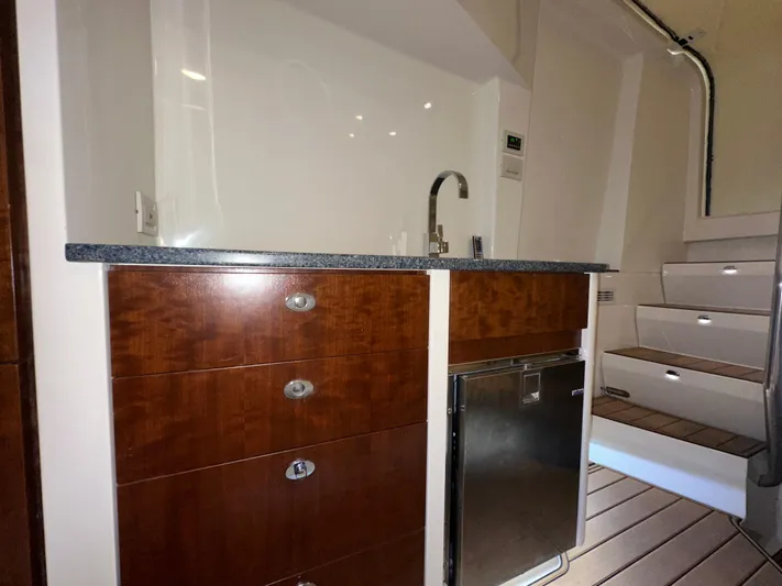 Wooocrew Yacht Photos Pics 2015 SeaVee 43 Fish-Around interior with wooden cabinetry, sink, and compact refrigerator.