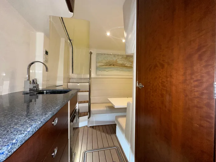 Wooocrew Yacht Photos Pics 2015 SeaVee 43 Fish-Around interior with kitchenette, seating area, and wooden cabinetry.