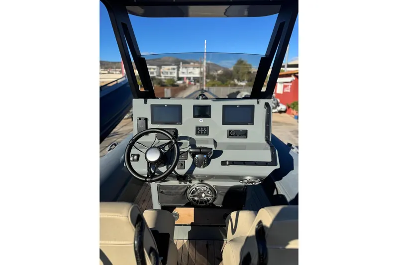  Yacht Photos Pics 2023 Rock Marine ROCK 30 boat dashboard with steering wheel and navigation screens.
