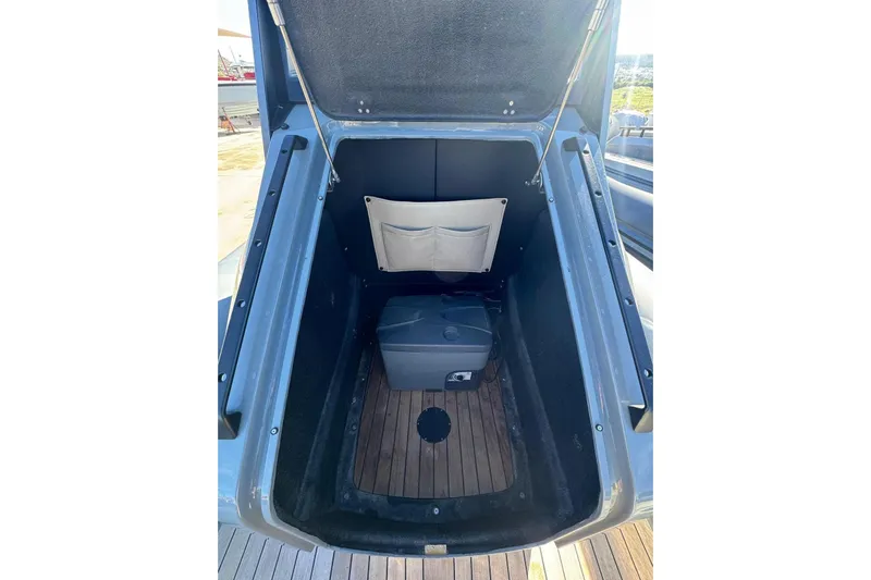  Yacht Photos Pics 2023 Rock Marine ROCK 30 boat storage compartment with wooden flooring and storage box.