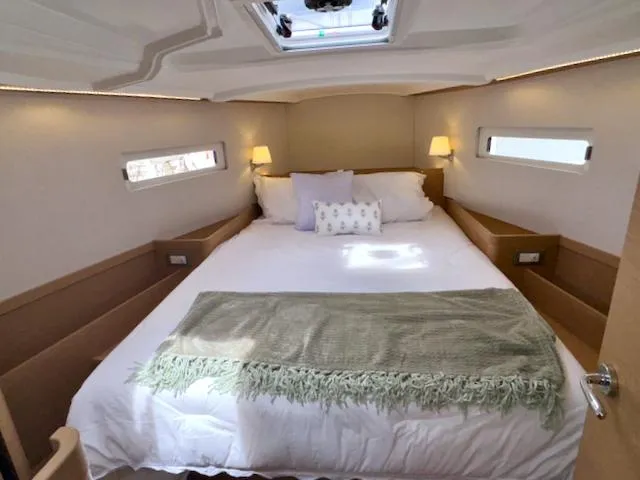 410 #345 In Stock Yacht Photos Pics Luxurious cabin interior of 2024 Jeanneau Sun Odyssey 410 yacht with cozy bedding.