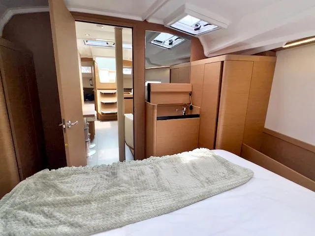 410 #345 In Stock Yacht Photos Pics 2024 Jeanneau Sun Odyssey 410 interior cabin with modern wood finish and cozy bedding.