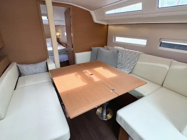 410 #345 In Stock Yacht Photos Pics Interior of 2024 Jeanneau Sun Odyssey 410, featuring a cozy dining area with cushioned seating.