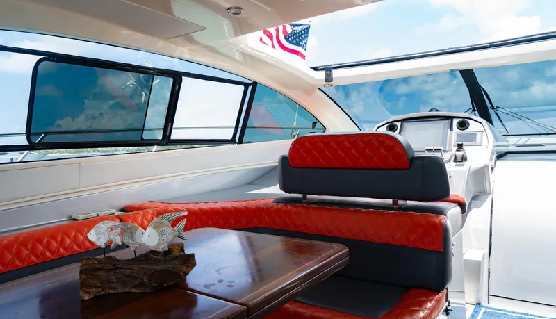D Padron Yacht Photos Pics Interior of 2013 Azimut Atlantis 58 yacht with red seating and wooden table.