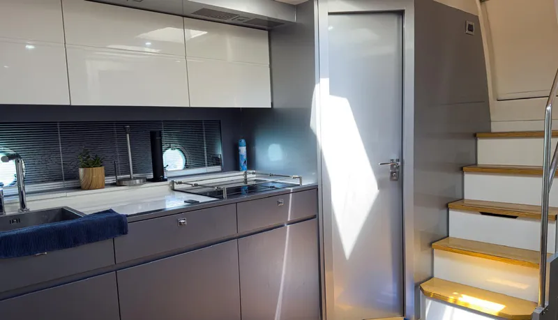 D Padron Yacht Photos Pics Modern kitchen interior of 2013 Azimut Atlantis 58 yacht with sleek cabinetry and stairs.