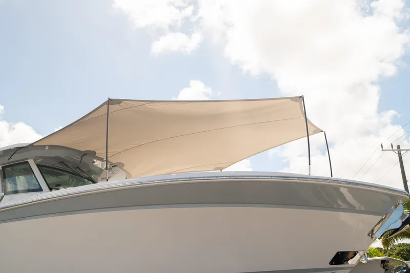  Yacht Photos Pics 2024 Blackfin 400 CC boat with canopy against a cloudy sky.