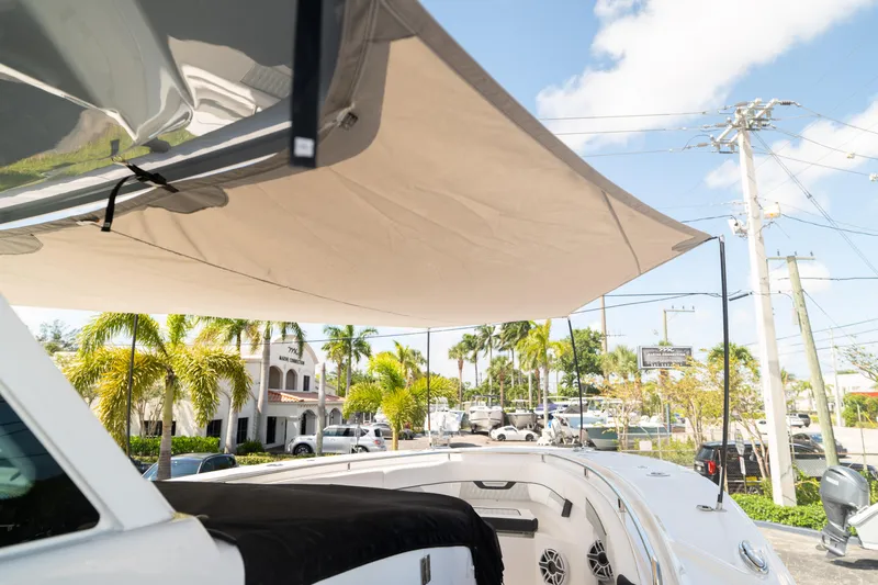  Yacht Photos Pics 2024 Blackfin 400 CC boat with sunshade, parked near palm trees and buildings.