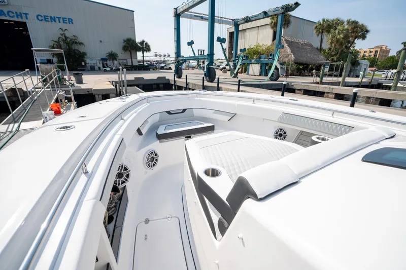  Yacht Photos Pics 2024 Blackfin 400 CC boat docked at a marina, showcasing spacious deck and seating area.