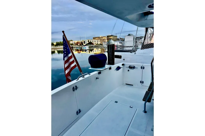 Kokomo Yacht Photos Pics Ocean Alexander 426 Classico 1997 yacht deck with American flag, docked at marina.