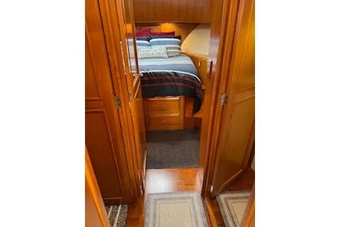 Kokomo Yacht Photos Pics 1997 Ocean Alexander 426 Classico cabin interior with wooden finish and cozy bedding.