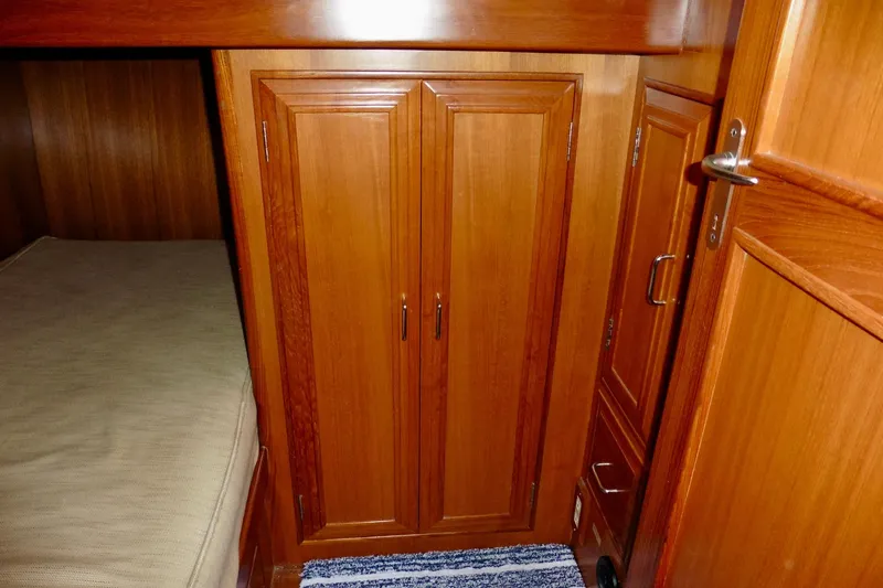 Kokomo Yacht Photos Pics Wooden cabin interior of 2000 Ocean Alexander 423 Classico yacht with storage and bed.