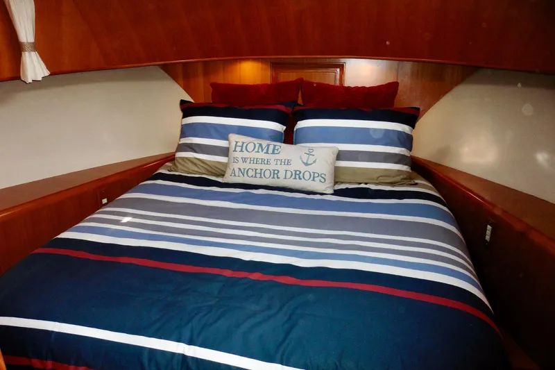 Kokomo Yacht Photos Pics Cozy bedroom in 2000 Ocean Alexander 423 Classico yacht with striped bedding and nautical decor.