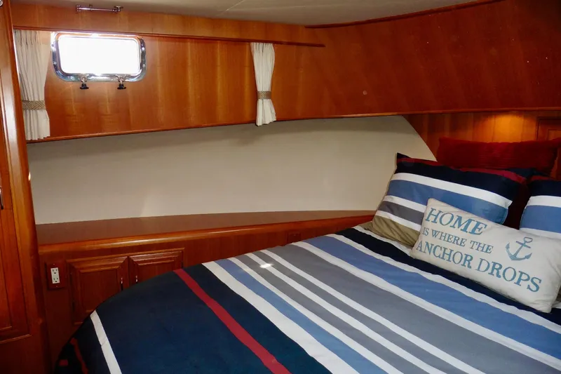 Kokomo Yacht Photos Pics Cozy cabin interior of 2000 Ocean Alexander 423 Classico with nautical-themed bedding.
