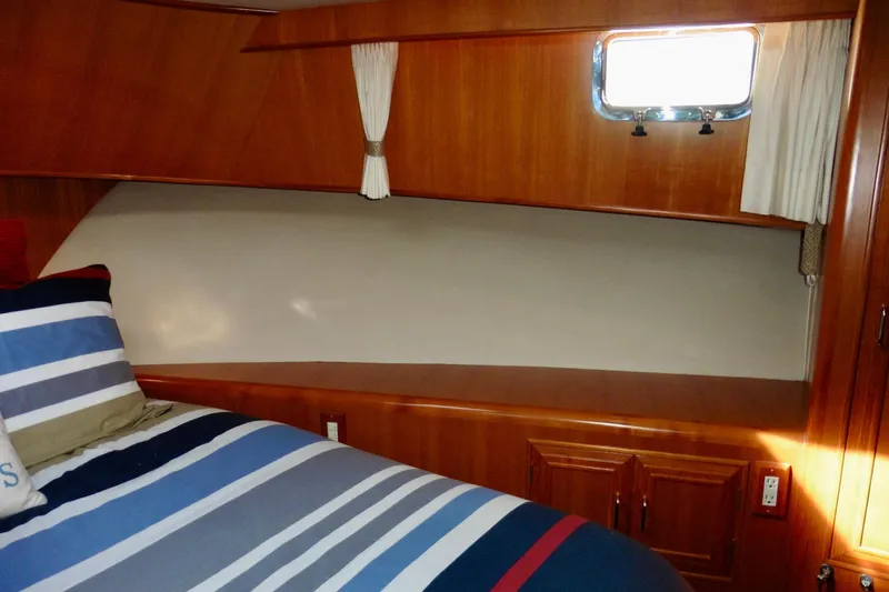 Kokomo Yacht Photos Pics Cozy cabin interior of 2000 Ocean Alexander 423 Classico with striped bedding and wooden finish.