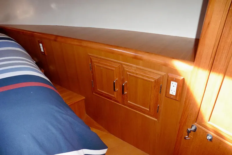 Kokomo Yacht Photos Pics Interior of 2000 Ocean Alexander 423 Classico with wooden cabinetry and striped bedding.