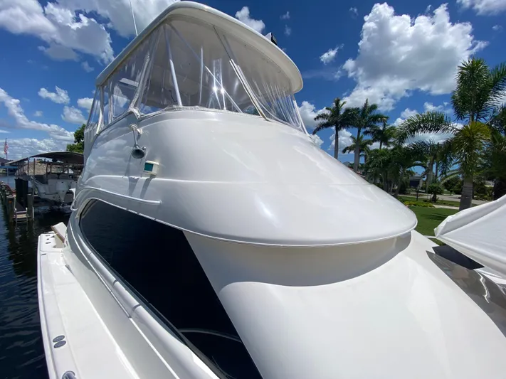 Pretty Fine Yacht Photos Pics 2003 Riviera 47 Convertible yacht docked under a clear blue sky with palm trees.