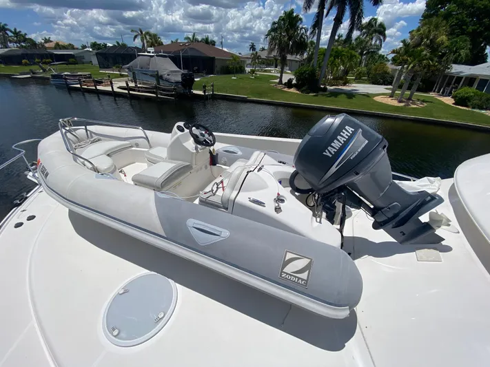 Pretty Fine Yacht Photos Pics Inflatable Zodiac boat with Yamaha motor on Riviera 47 Convertible, 2003 model, docked by a canal.