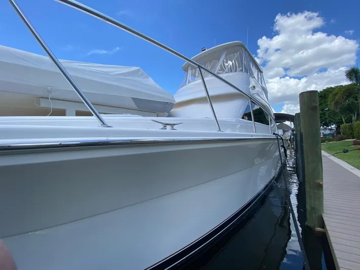 Pretty Fine Yacht Photos Pics 2003 Riviera 47 Convertible yacht docked under a clear blue sky.