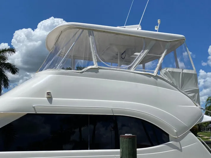 Pretty Fine Yacht Photos Pics 2003 Riviera 47 Convertible yacht with clear canopy under a bright blue sky.