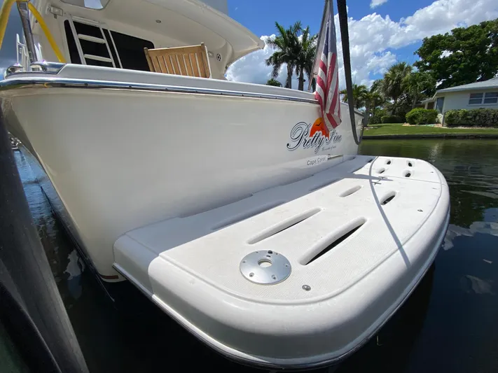 Pretty Fine Yacht Photos Pics 2003 Riviera 47 Convertible yacht with swim platform, docked in a sunny, tropical setting.