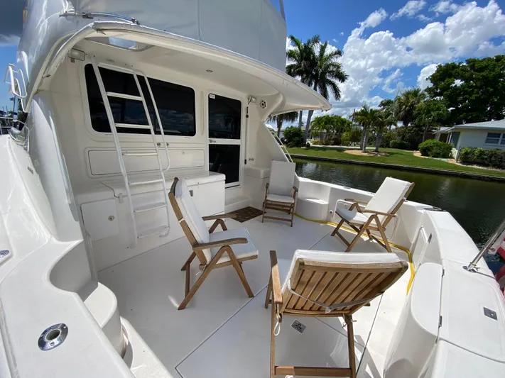 Pretty Fine Yacht Photos Pics 2003 Riviera 47 Convertible yacht deck with chairs, ladder, and scenic canal view.