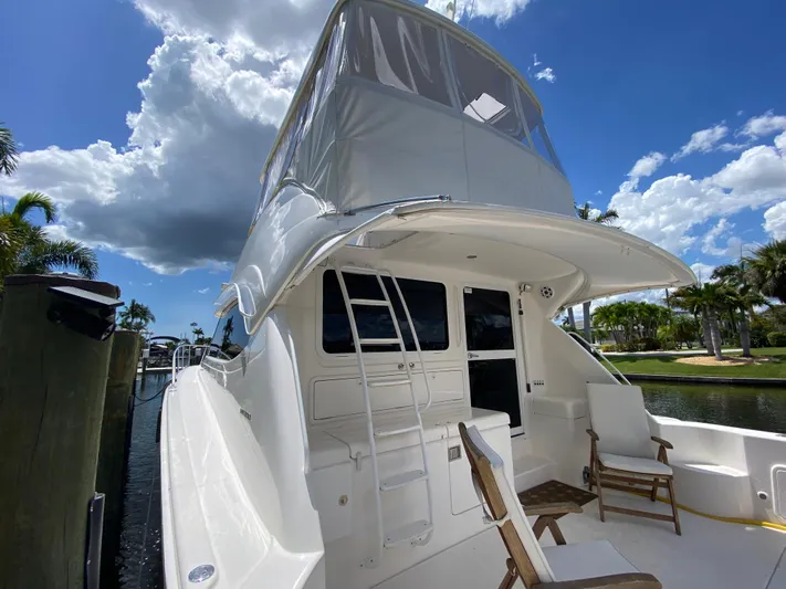 Pretty Fine Yacht Photos Pics 2003 Riviera 47 Convertible yacht docked under a partly cloudy sky.