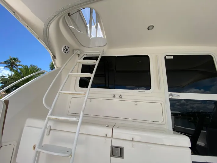 Pretty Fine Yacht Photos Pics Ladder and windows on a 2003 Riviera 47 Convertible yacht under a clear blue sky.