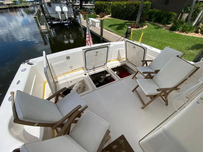 Pretty Fine Yacht Photos Pics 2003 Riviera 47 Convertible yacht deck with open hatches and cushioned chairs.