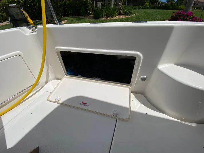 Pretty Fine Yacht Photos Pics 2003 Riviera 47 Convertible boat deck with open storage compartment and yellow hose.