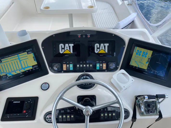 Pretty Fine Yacht Photos Pics 2003 Riviera 47 Convertible yacht helm with navigation screens and controls.