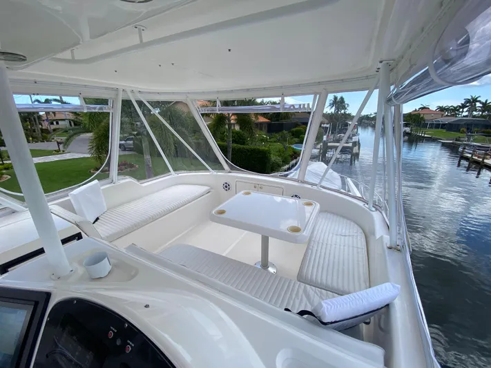 Pretty Fine Yacht Photos Pics 2003 Riviera 47 Convertible yacht interior with seating and table, overlooking a serene waterfront.