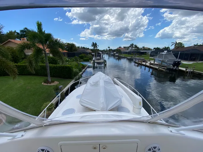 Pretty Fine Yacht Photos Pics 2003 Riviera 47 Convertible yacht cruising through a scenic canal with palm trees.