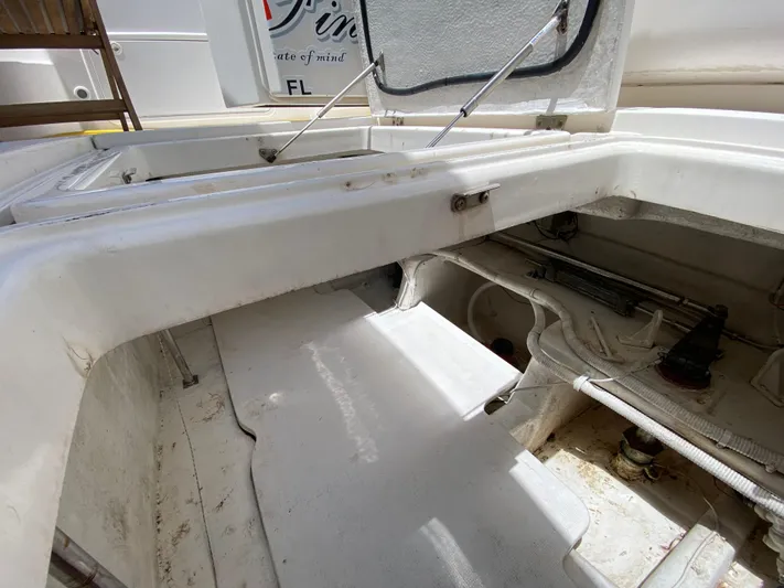 Pretty Fine Yacht Photos Pics Open hatch of a 2003 Riviera 47 Convertible boat, showing interior compartments.