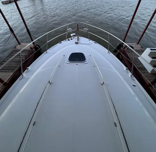 Lucky 9 Yacht Photos Pics 2007 Sea Ray 38 Sundancer yacht bow view at dock, overlooking calm water.