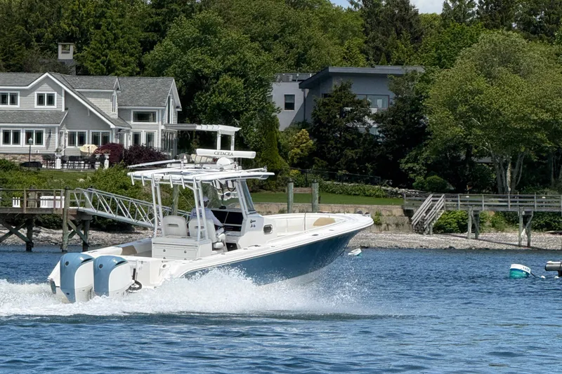  Yacht Photos Pics 2017 Edgewater 320CC boat cruising near waterfront homes and lush greenery.