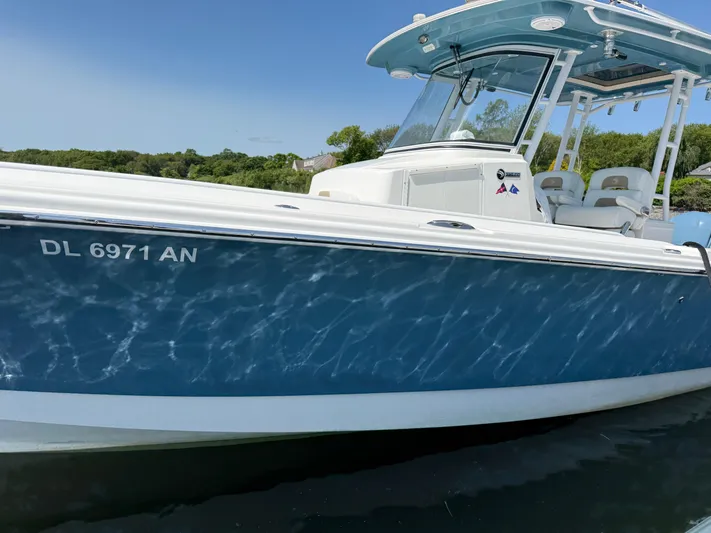  Yacht Photos Pics 2017 Edgewater 320CC boat on water, blue hull, clear sky background.