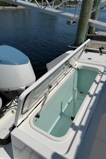  Yacht Photos Pics 2017 Edgewater 320CC boat with open storage compartment by the water.