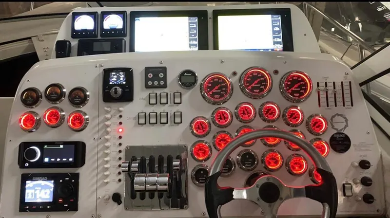 Dealer-ship Yacht Photos Pics Control panel of a 2004 Fountain 48 Express Cruiser with illuminated gauges and navigation screens.